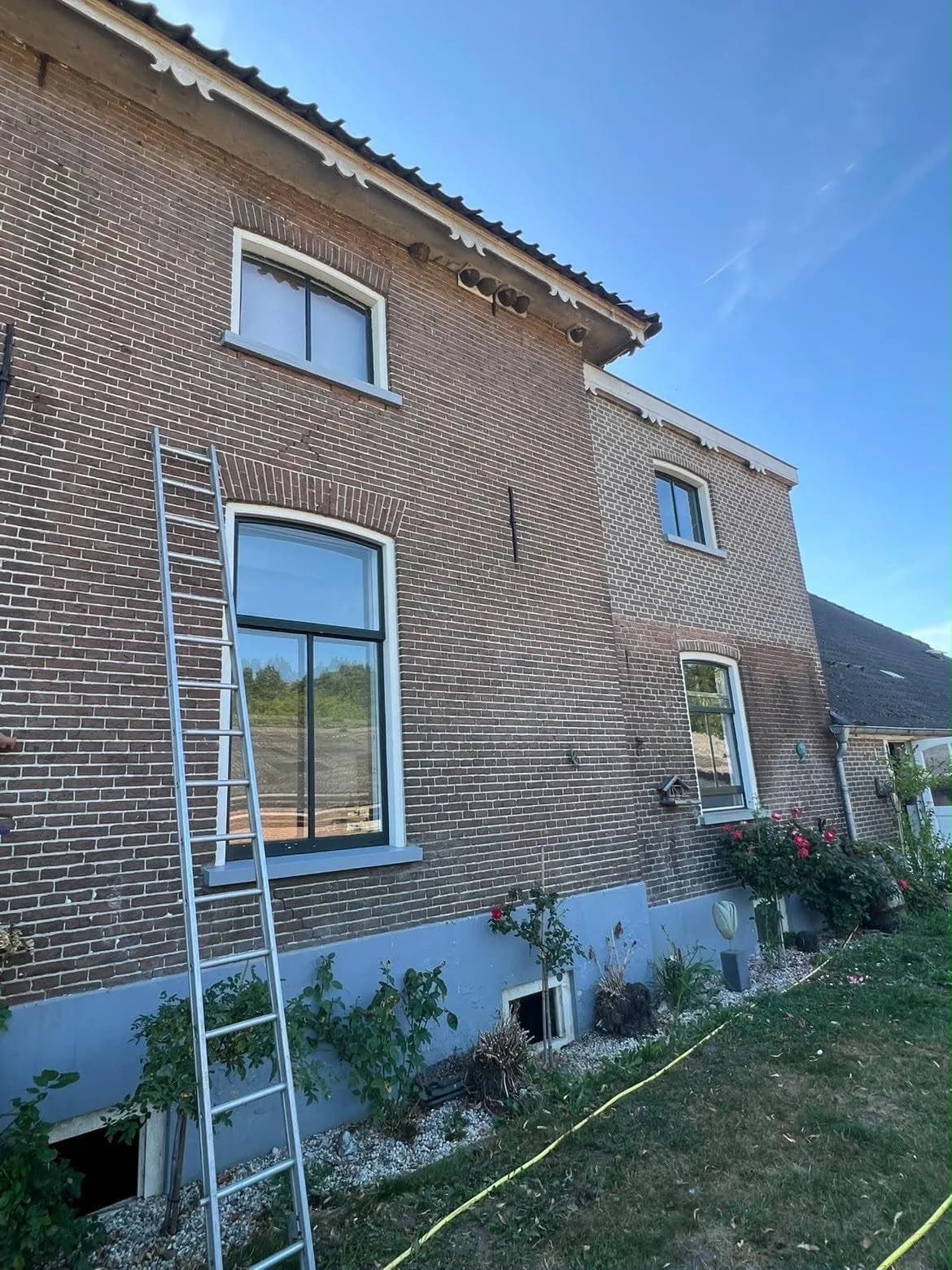 Hoge ramen van een oude woning, ladder ertegen