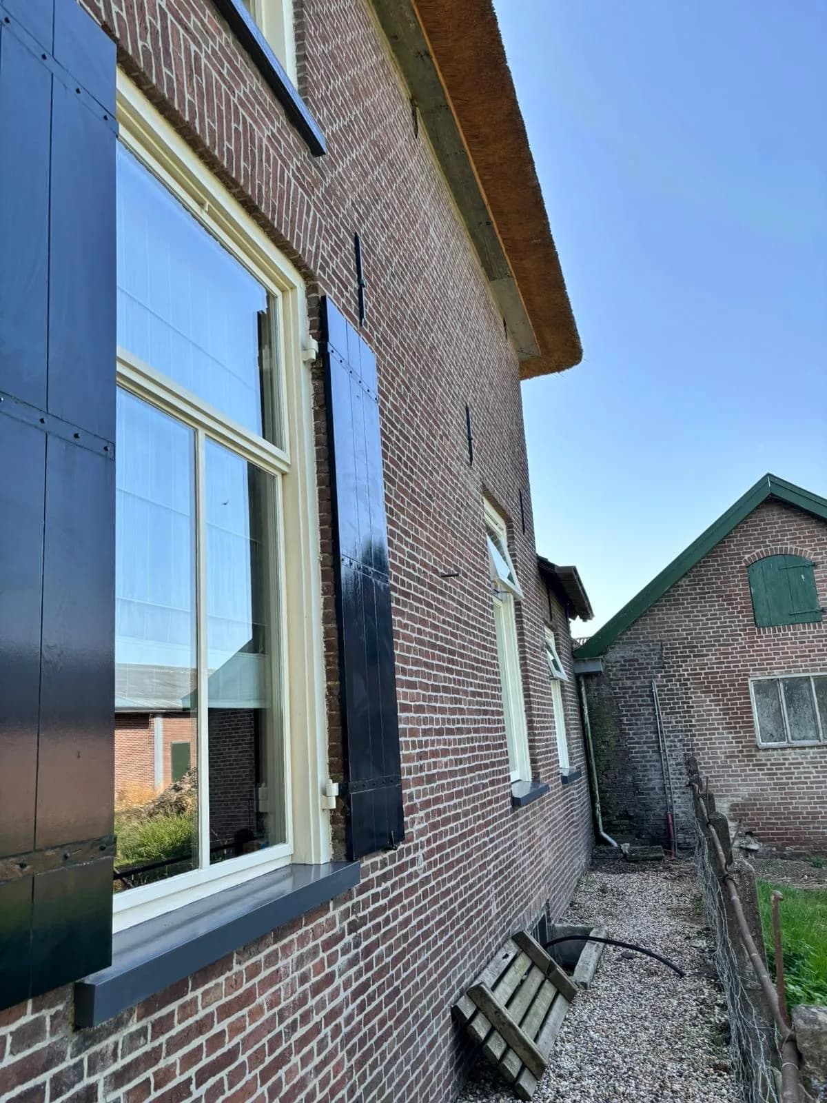 Schoon raam met luiken in een oude zijgevel