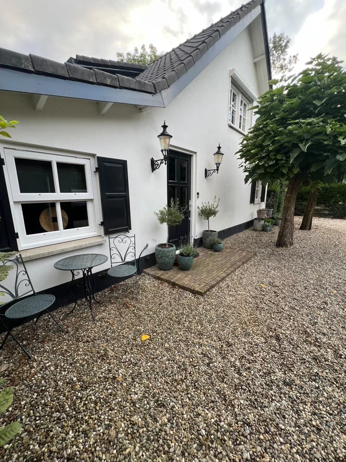 Witte woning met zwarte luiken en gewassen ramen