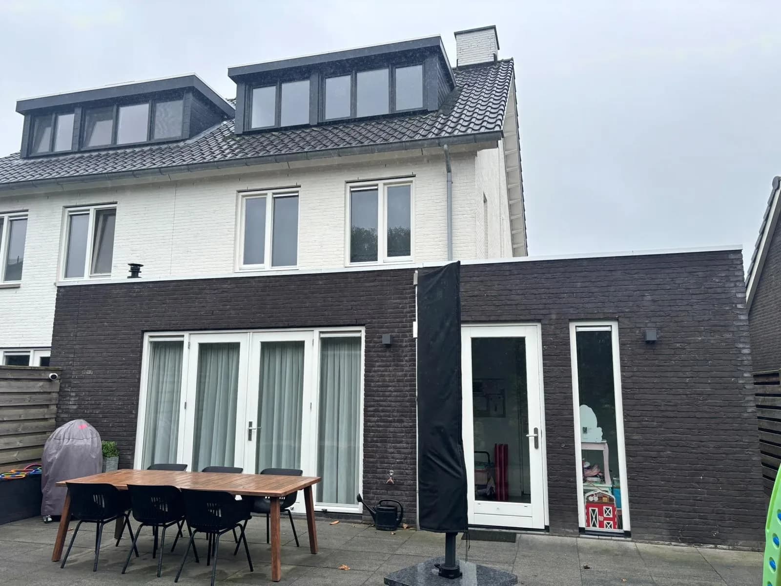Achtergevel van een nieuwbouwwoning met grote openslaande deuren
