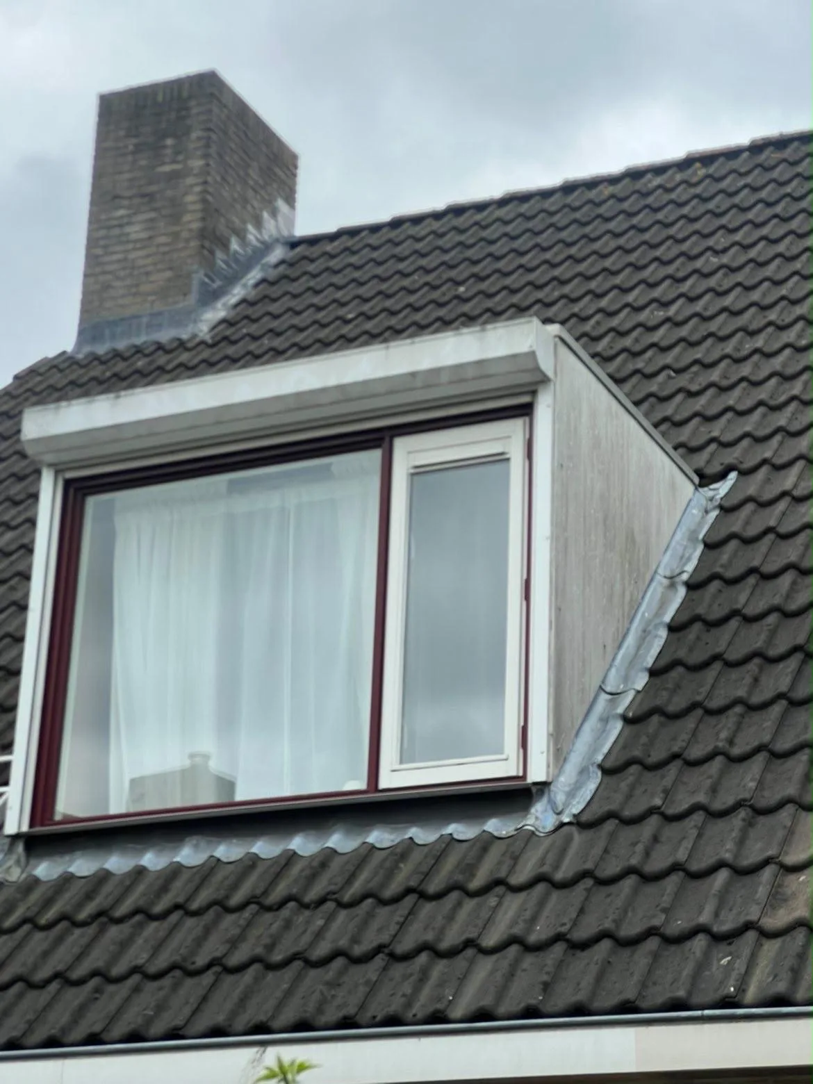 Dakkapel met rood kozijn en witte boeidelen