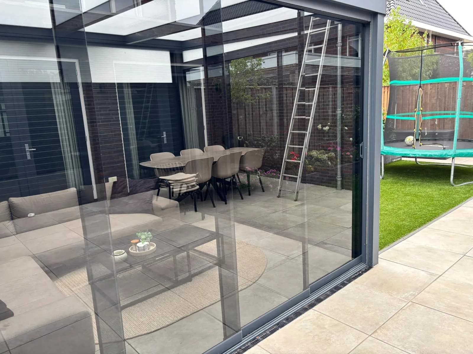 Veranda met glazen wanden, de ladder staat er nog