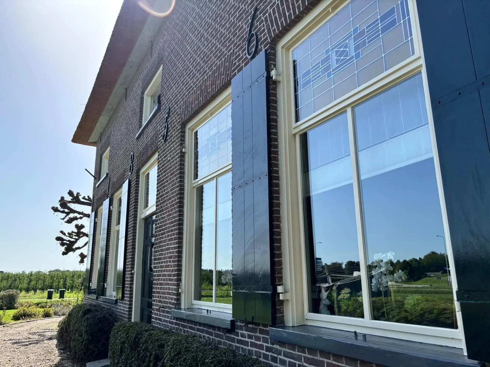 Hoge ramen met groene luiken van een boerderijwoning